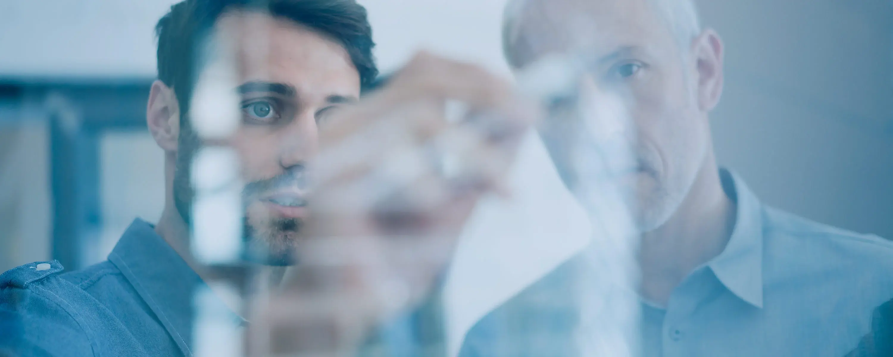 Bild von zwei Managern welche Anbieter und Hersteller von MES Systemen an einem Whiteboard besprechen